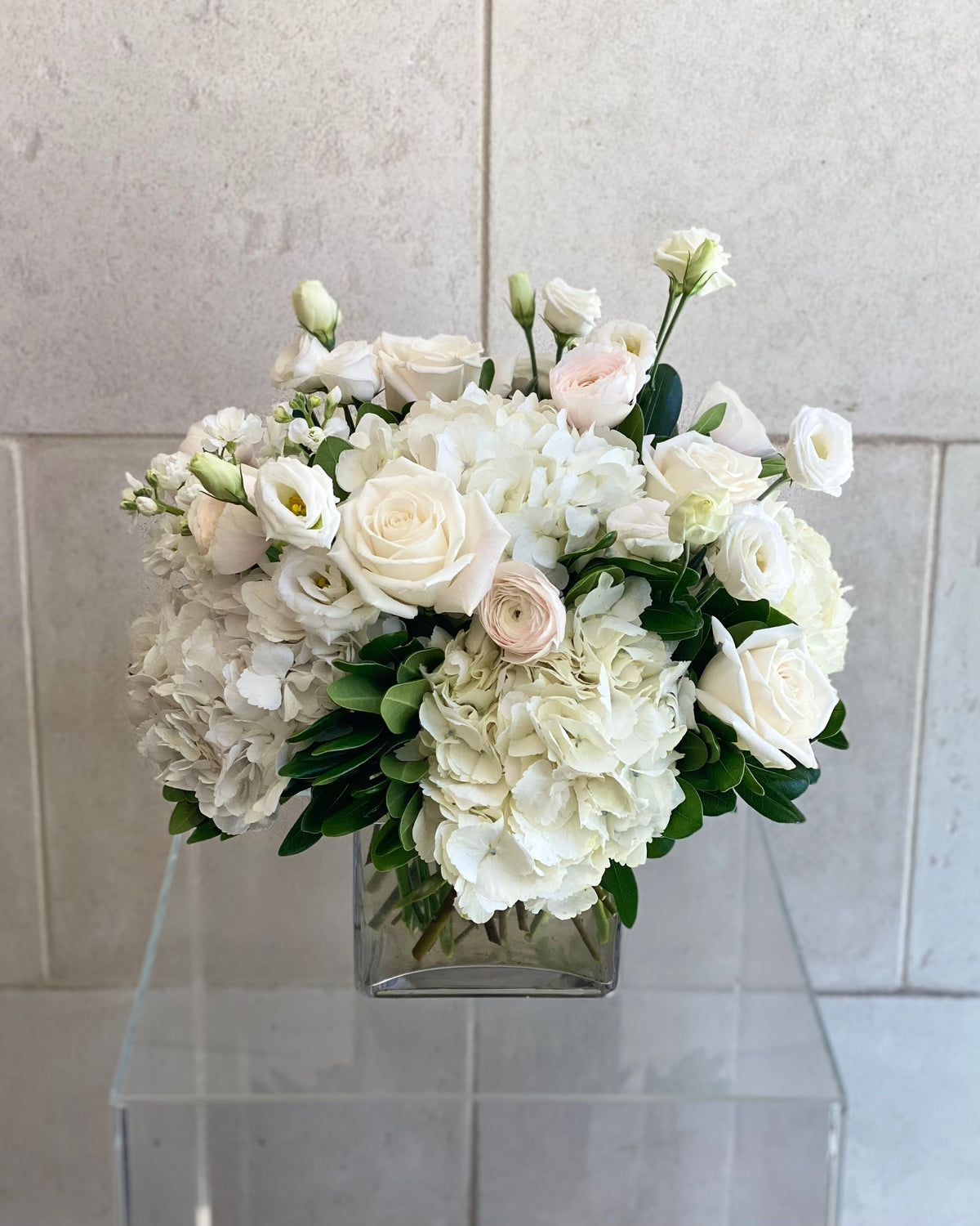Blush and white vase arrangement with seasonal flowers in soft pink, cream, and white tones.