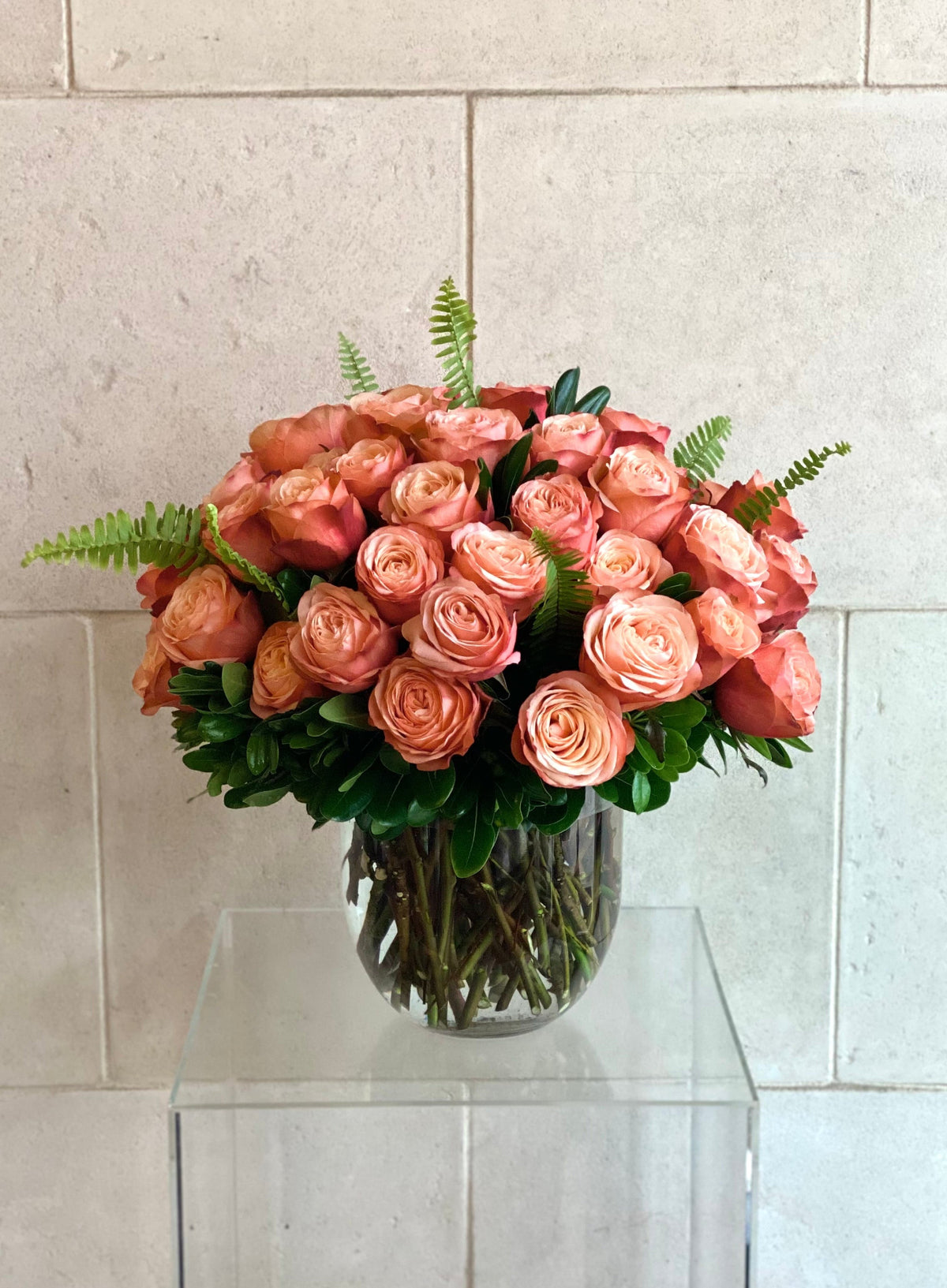 Kahala rose arrangement with peach and blush roses, fresh greenery, and a clear glass vase.
