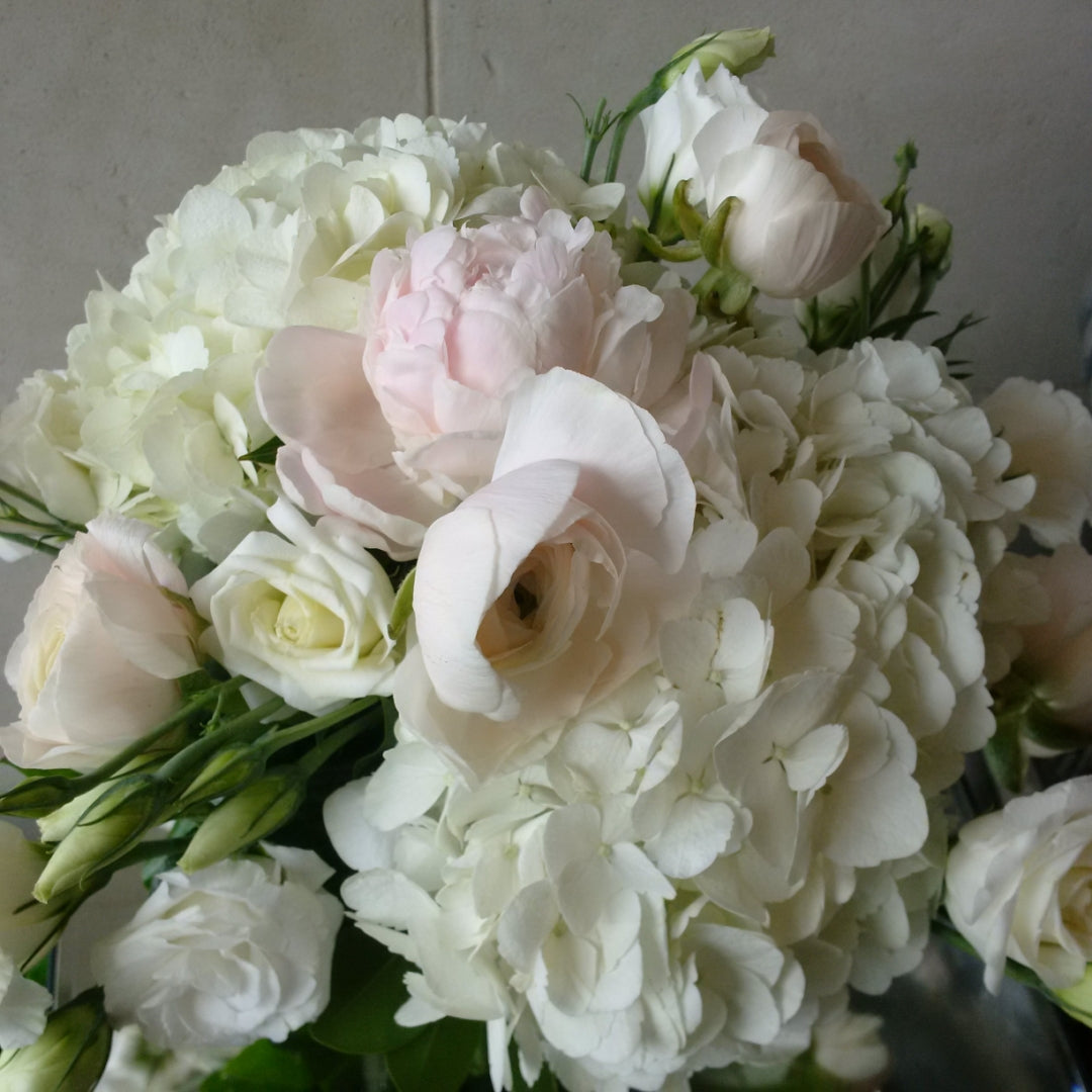 Blush and white vase arrangement with seasonal flowers in soft pink, cream, and white tones.