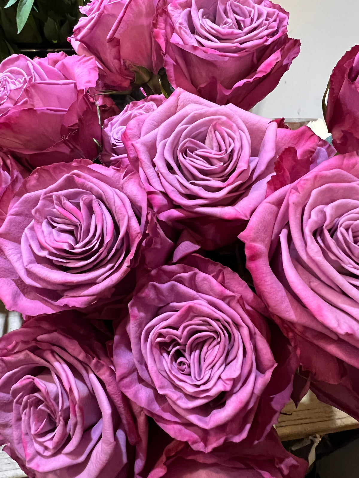 Dozen roses with seasonal accent flowers and fresh greenery, available as a hand-tied bouquet or vase arrangement.