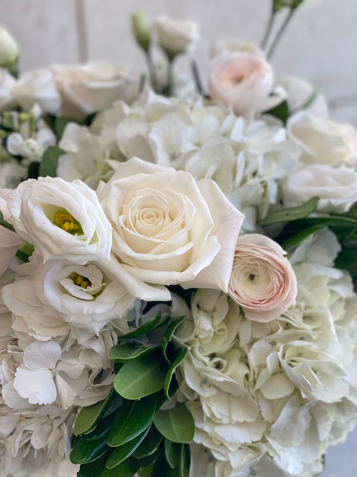 Blush and white vase arrangement with seasonal flowers in soft pink, cream, and white tones.