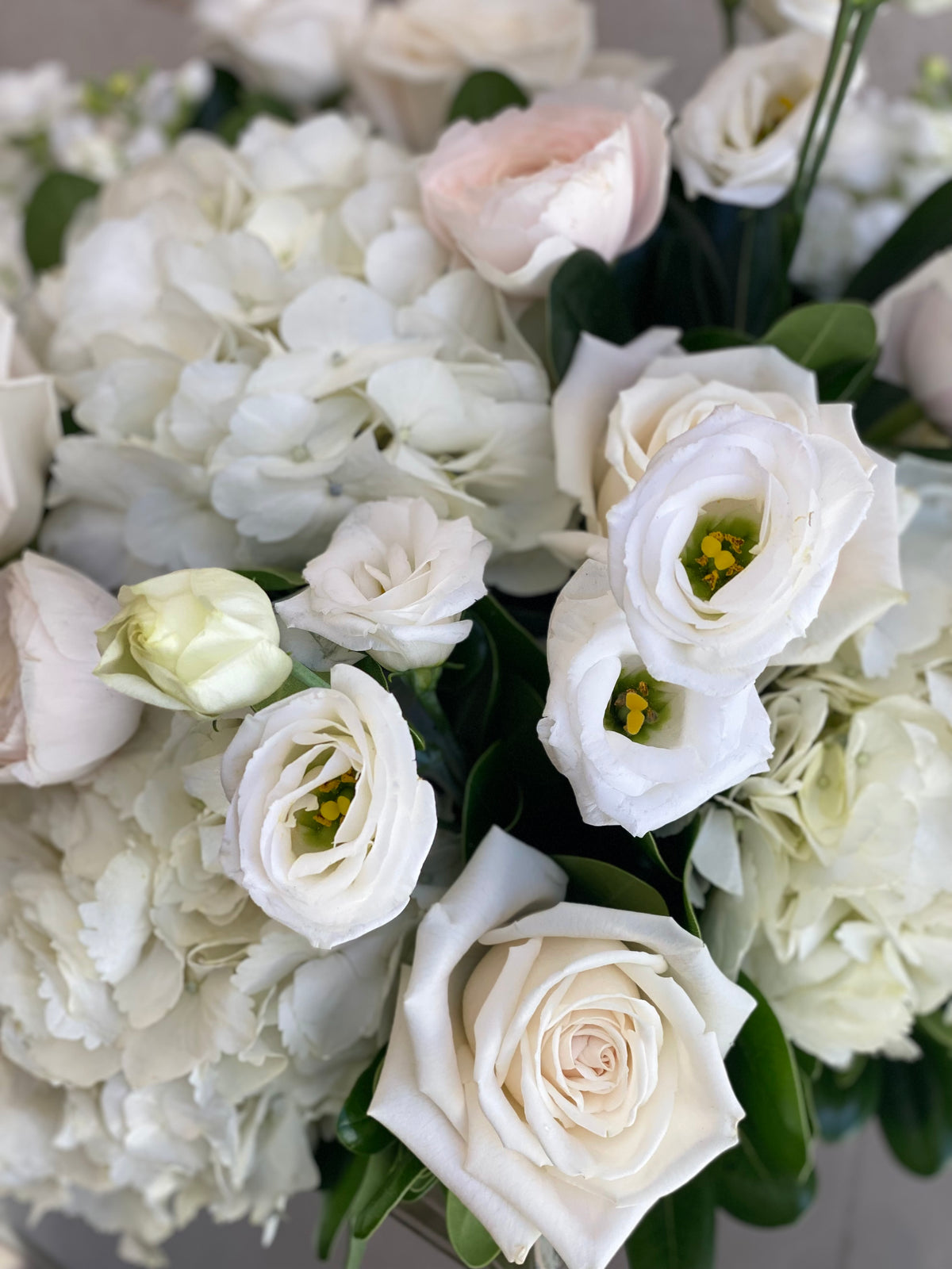 Blush and white vase arrangement with seasonal flowers in soft pink, cream, and white tones.